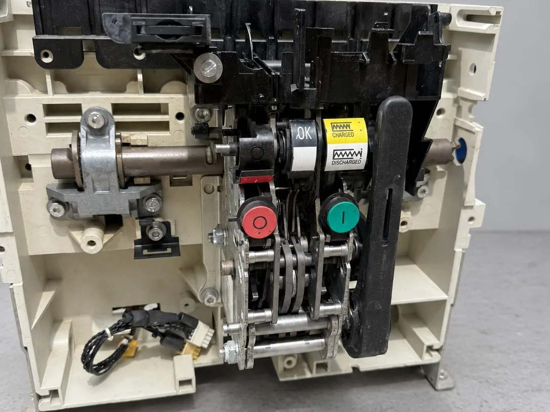 Siemens 3WL air circuit breaker stripped to the frame on the workshop bench: operating mechanism, charging shaft and pushbuttons exposed